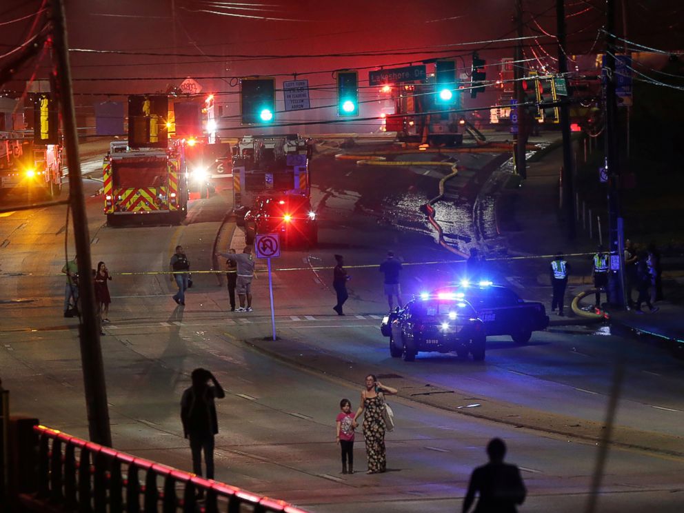 PHOTO: People make their way away from the bridge fire on Piedmont Road as emergency personnel work the scene of a bridge collapse at I-85 in Atlanta, Georgia, March 30, 2017. 