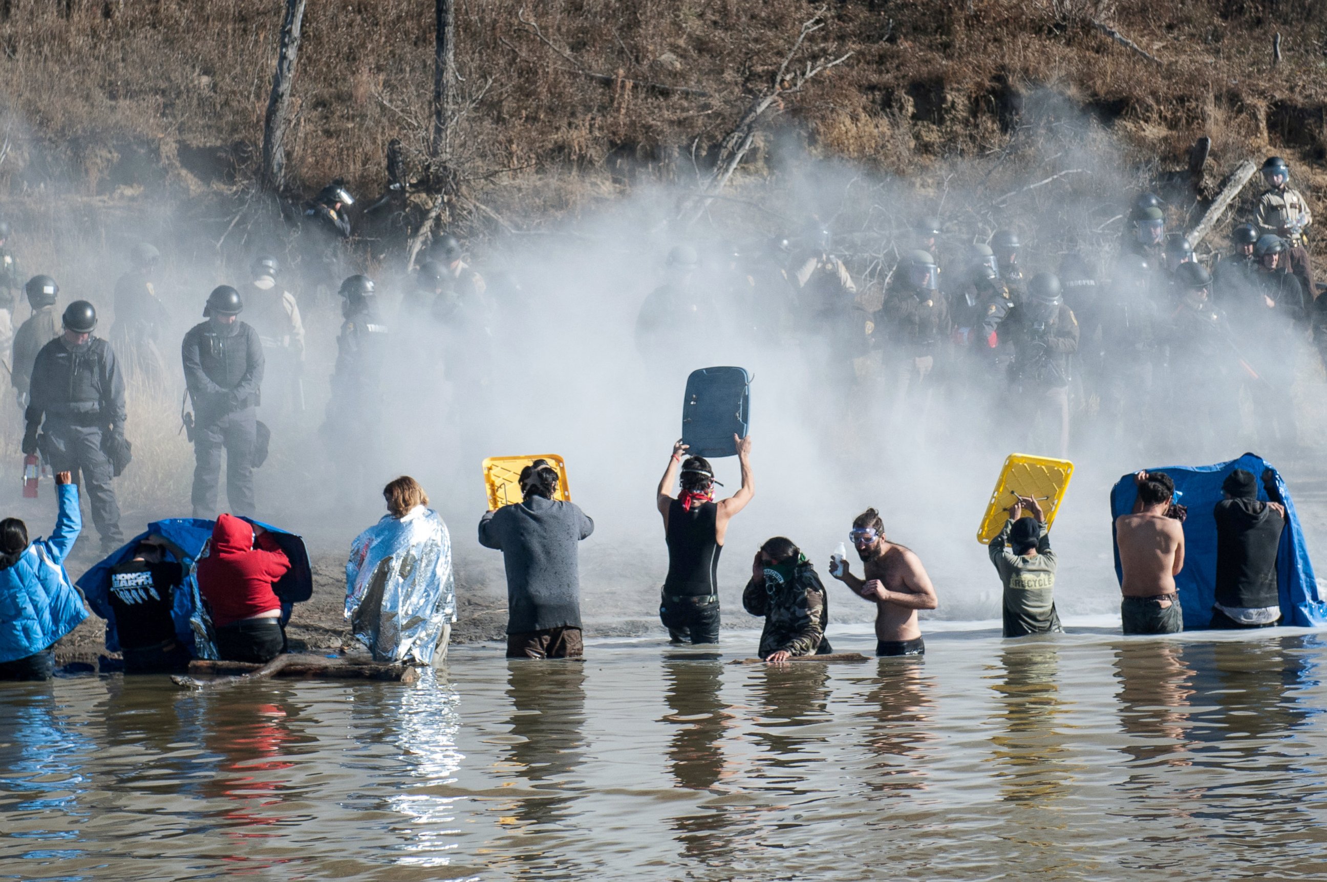PHOTO: Police use pepper spray against protestors standing in the water of a river during a protest against the building of a pipeline near the Standing Rock Indian Reservation near Cannonball, North Dakota, Nov. 2, 2016.