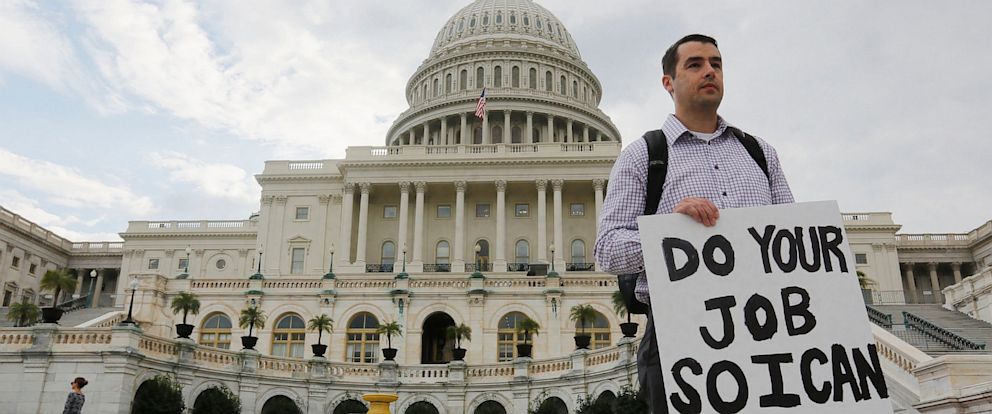 PHOTO: A furloughed federal employee holds a sign on the steps to the U.S. Capitol after the U.S. Government shut down last night, on Capitol Hill in Washington on October 1, 2013.