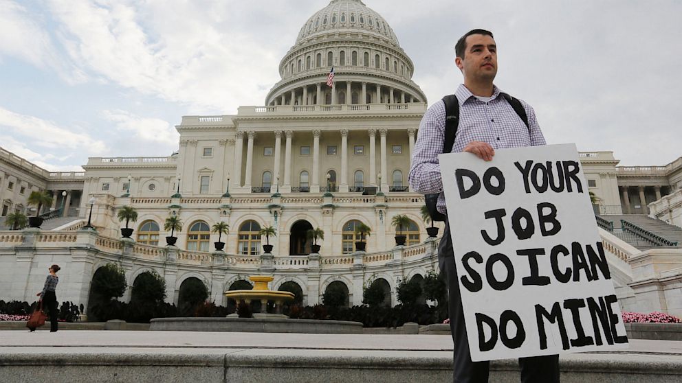 PHOTO: A furloughed federal employee holds a sign on the steps to the U.S. Capitol after the U.S. Government shut down last night, on Capitol Hill in Washington on October 1, 2013.