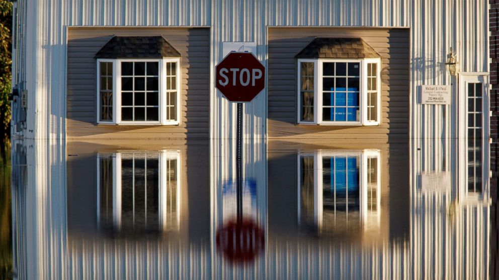 PHOTO: A building and street signs are reflected in flood waters as the Tar River rises to dangerous levels in the aftermath of Hurricane Matthew, in Tarboro, North Carolina, on Oct. 13, 2016. 