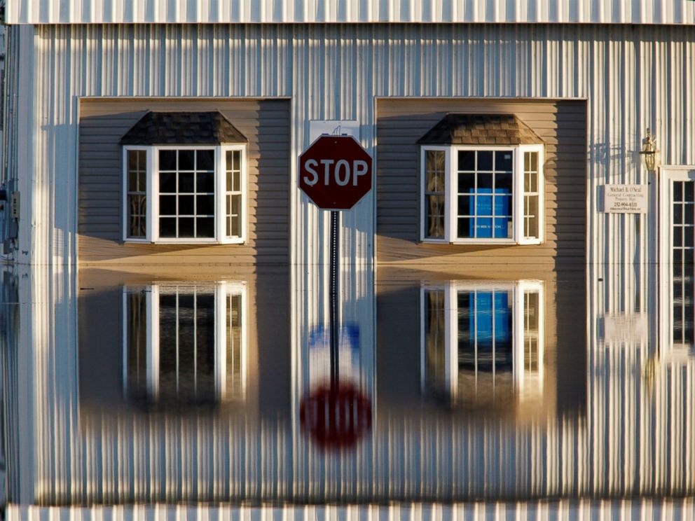 PHOTO: A building and street signs are reflected in flood waters as the Tar River rises to dangerous levels in the aftermath of Hurricane Matthew, in Tarboro, North Carolina, on Oct. 13, 2016.