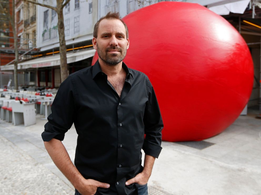 PHOTO: Artist Kurt Perschke poses with his huge red ball as part of his RedBall Project in Paris on April 18, 2013.