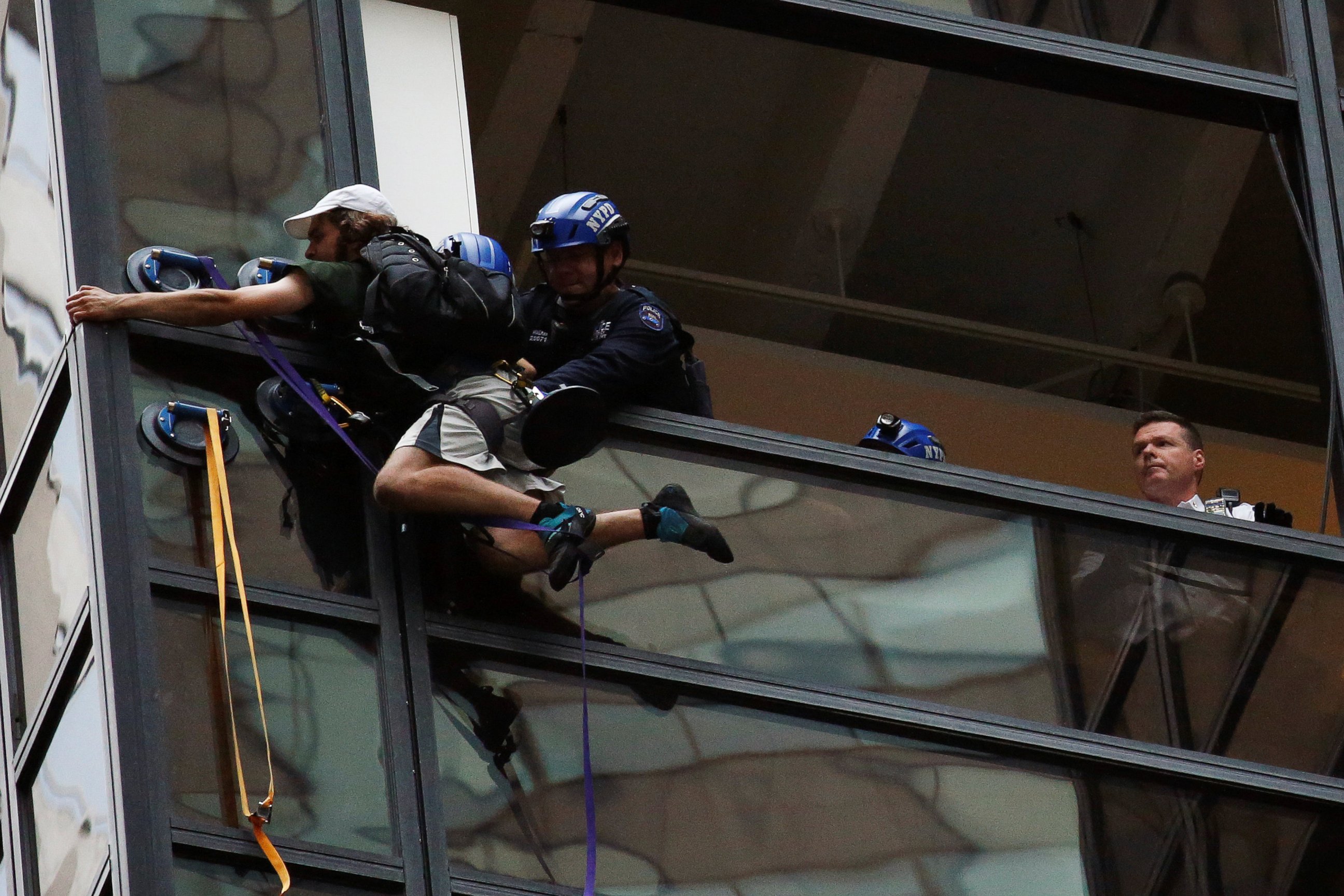 PHOTO:Officers from the NYPD embrace a man to stop him from climbing the outside of Trump Tower in New York, Aug. 10, 2016.  