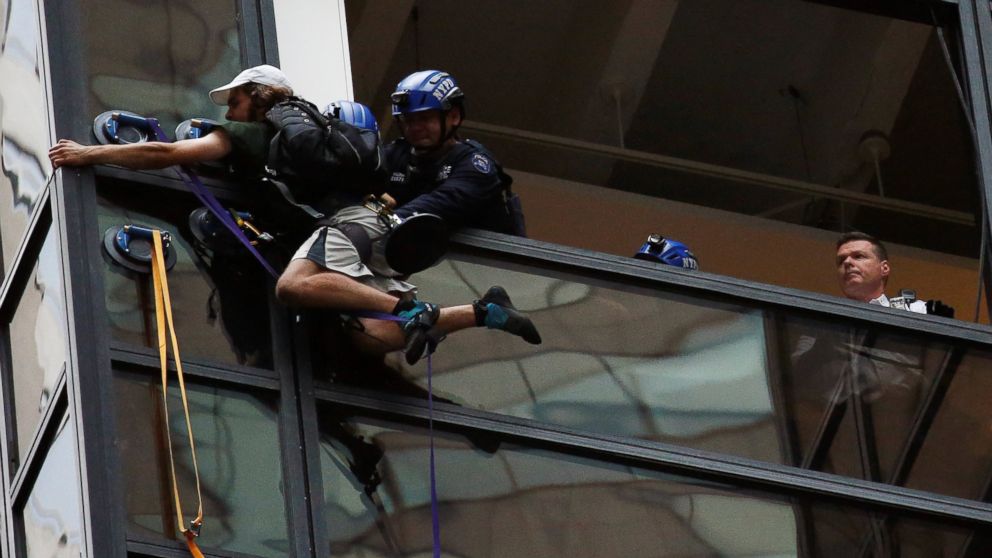 PHOTO:Officers from the NYPD embrace a man to stop him from climbing the outside of Trump Tower in New York, Aug. 10, 2016.  