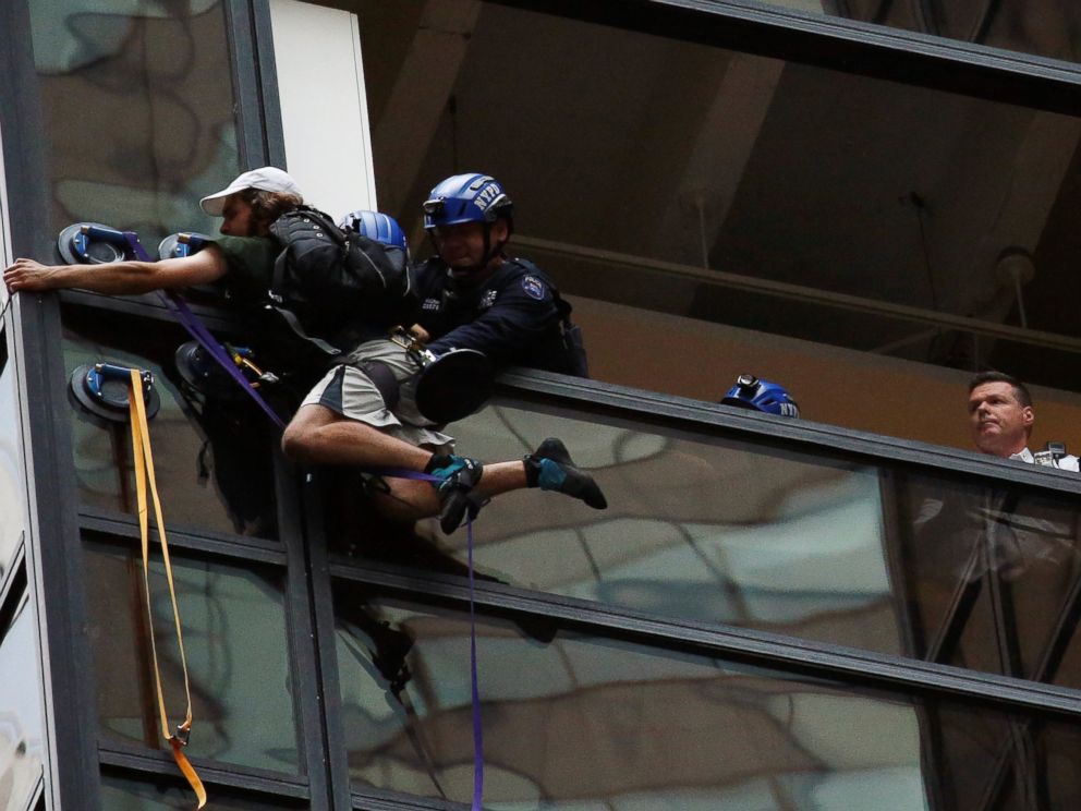 PHOTO:Officers from the NYPD embrace a man to stop him from climbing the outside of Trump Tower in New York, Aug. 10, 2016.