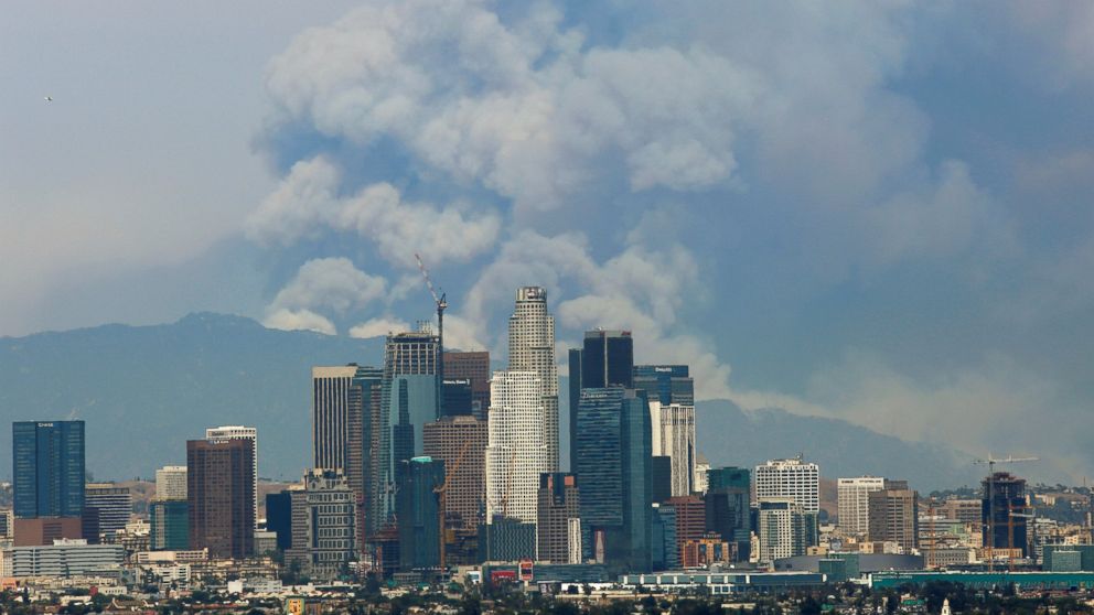 PHOTO: Smoke from two fires burning in the Angeles National Forest rises with the downtown skyline in the foreground in Los Angeles, June 20, 2016. 