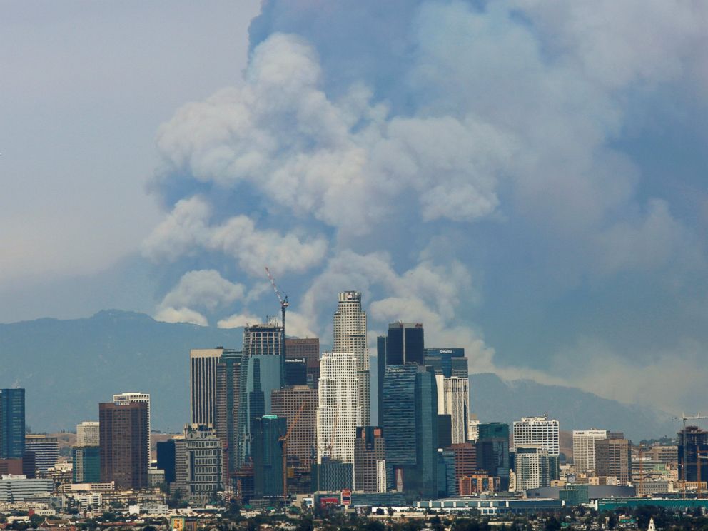 PHOTO: Smoke from two fires burning in the Angeles National Forest rises with the downtown skyline in the foreground in Los Angeles, June 20, 2016.