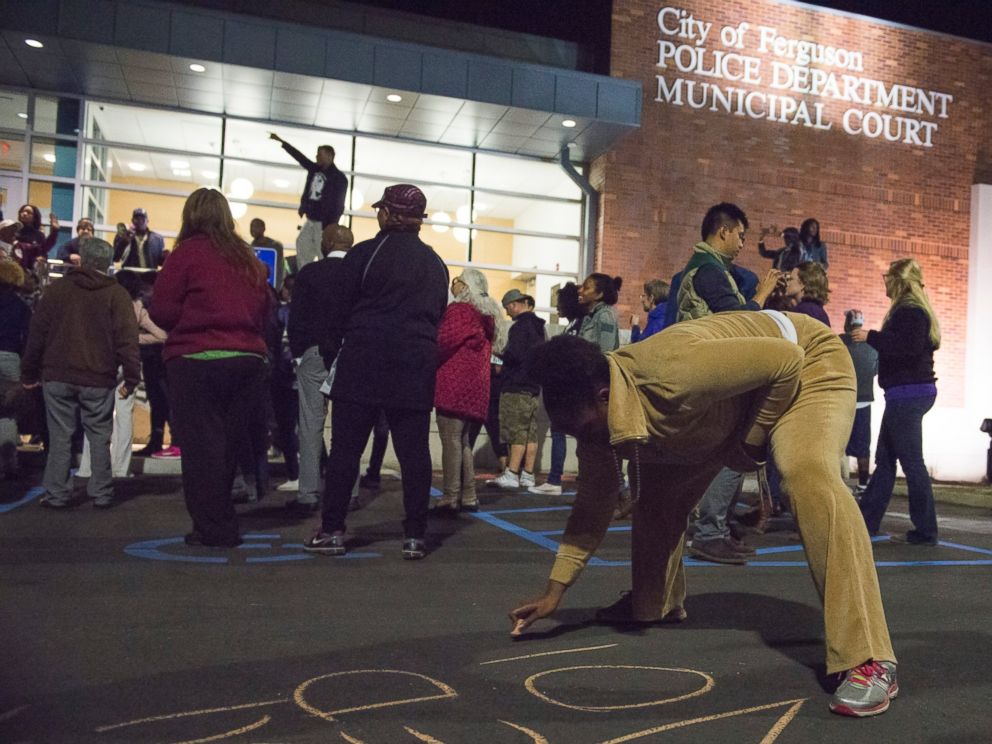 PHOTO: Protesters write slogans in chalk outside the City of Ferguson Police Department and Municipal Court in Ferguson, Mo., March 11, 2015.