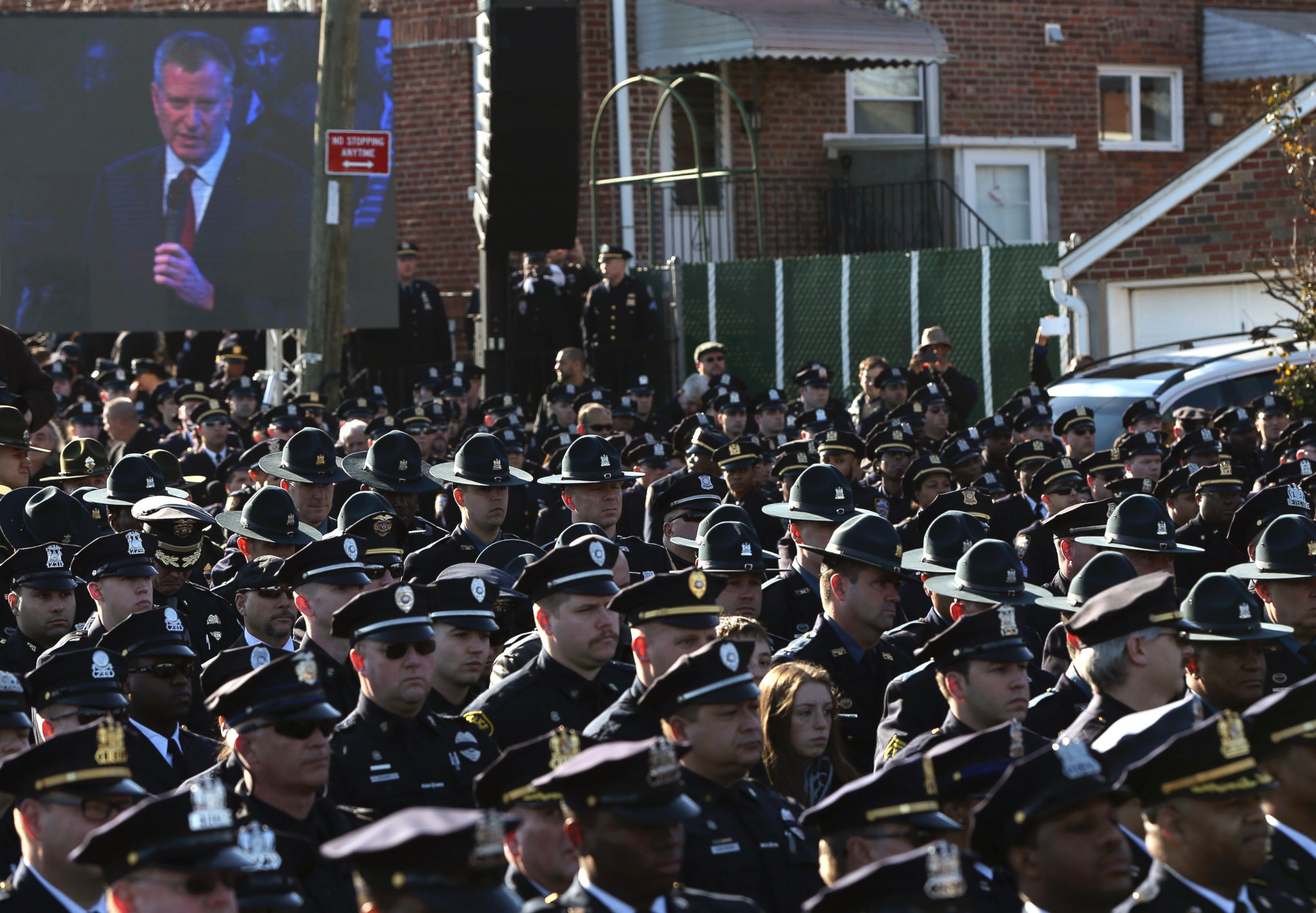 PHOTO: Law enforcement officers turn their backs on a video monitor as New York City Mayor Bill de Blasio speaks during the funeral of slain New York Police Department officer Rafael Ramos in the Queens borough of New York on Dec. 27, 2014.