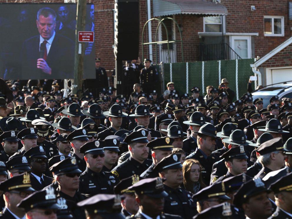PHOTO: Law enforcement officers turn their backs on a video monitor as New York City Mayor Bill de Blasio speaks during the funeral of slain New York Police Department officer Rafael Ramos in the Queens borough of New York on Dec. 27, 2014.