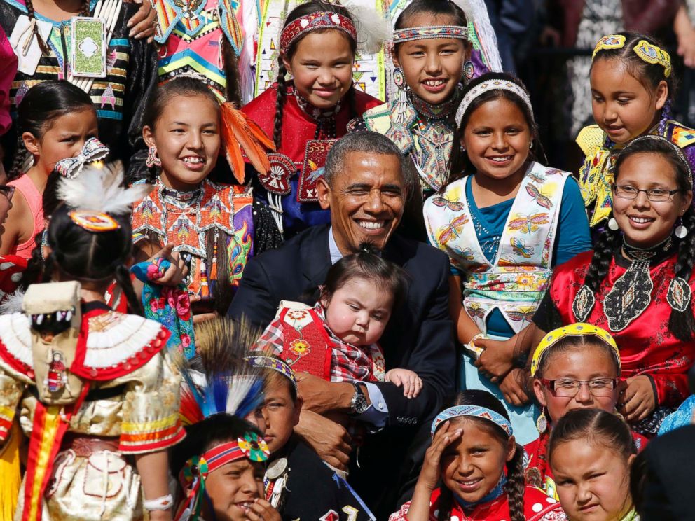 PHOTO: Barack Obama holds a baby as he poses with children at the Cannon Ball Flag Day Celebration at the Cannon Ball Powwow Grounds on the Standing Rock Sioux Reservation in North Dakota, June 13, 2014. 