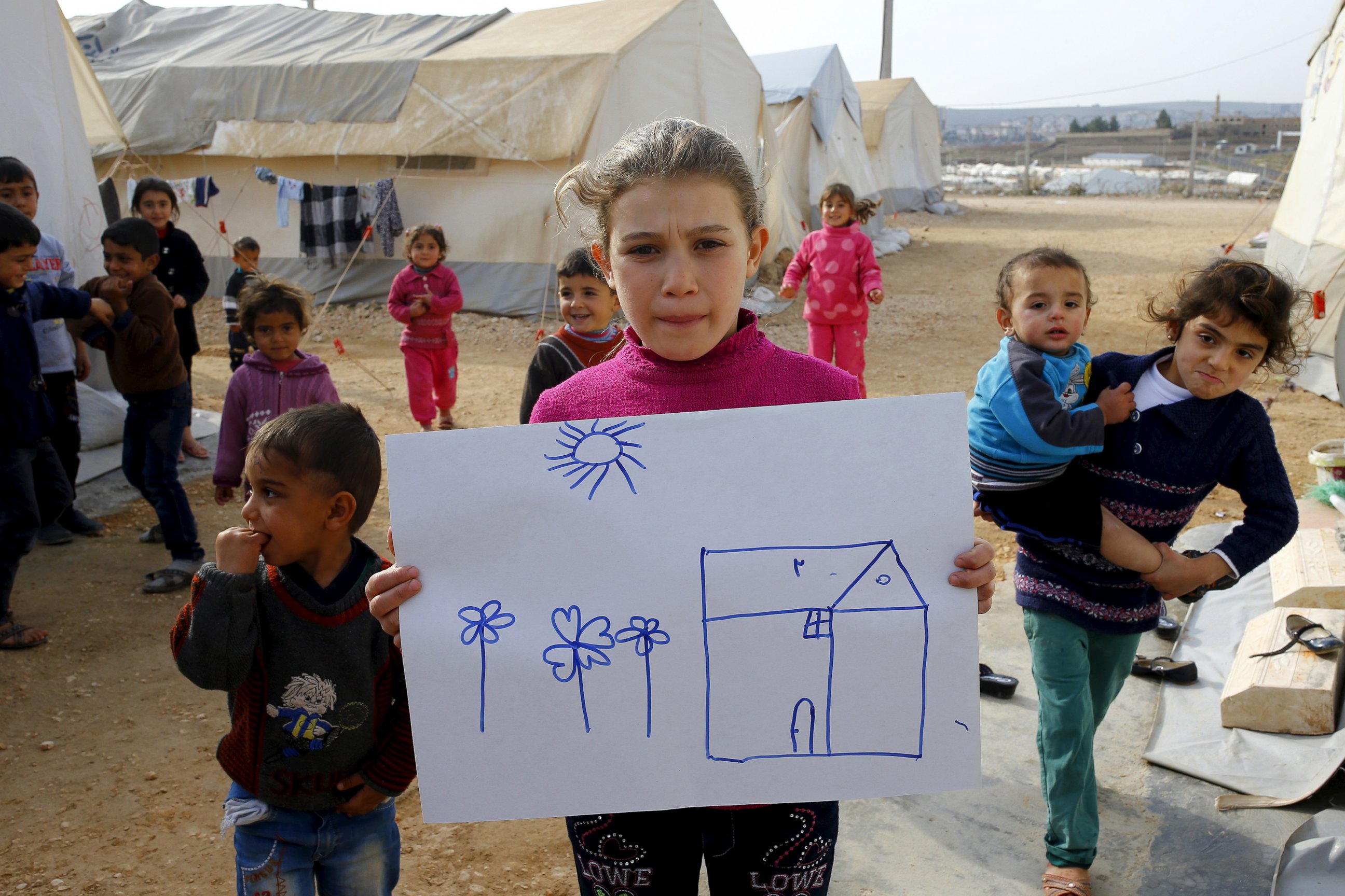 PHOTO: Syrian refugee Rahaf Hasan, 10, poses as she holds a drawing of her home in Syria in Midyat refugee camp in Mardin province, Turkey, Dec. 14, 2015. 