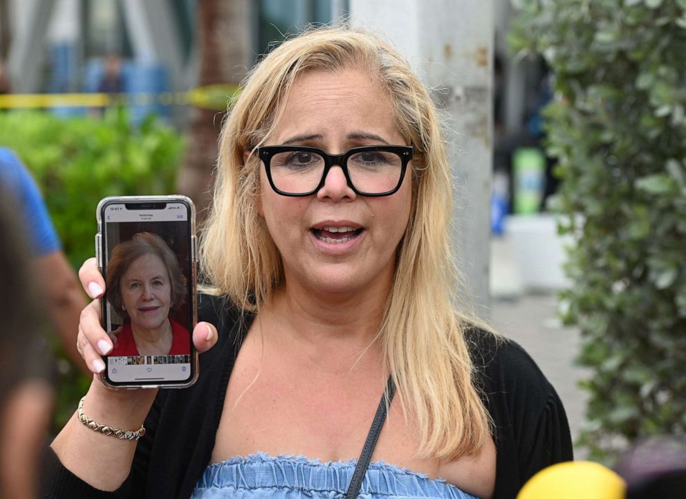 PHOTO: Magaly Ramsey hold up a photo of her mother, Magaly Delgado, on her phone as family members remain missing after the collapsed Champlain Towers South building in Surfside, Fla., Jun 25 2021.