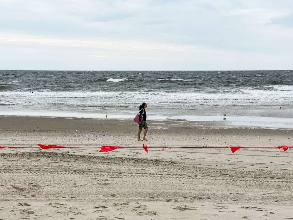 PHOTO: A person walks by the ocean in Rockaway Beach during Labor Day Weekend, Sept. 5, 2021, in New York.