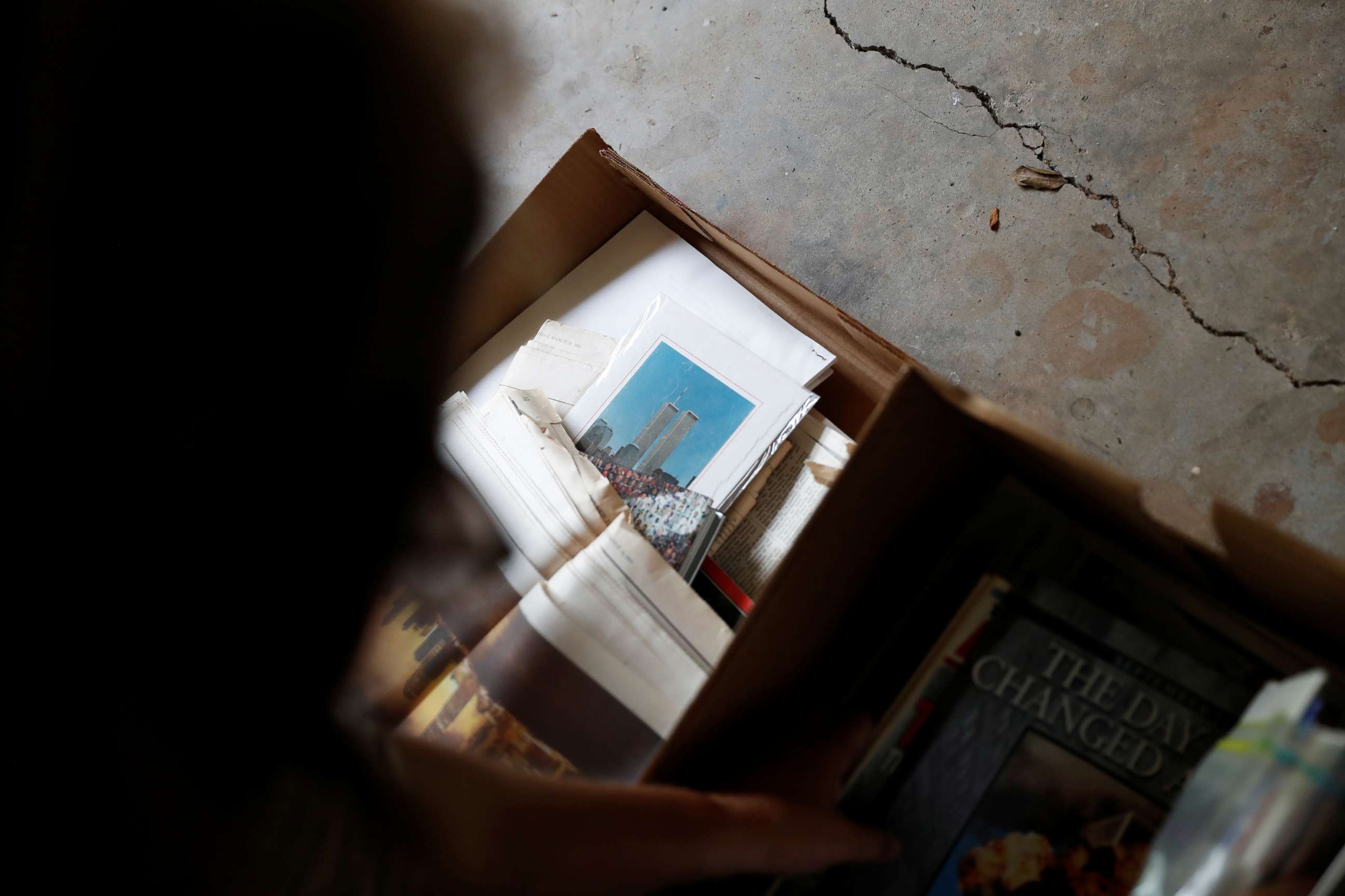 PHOTO: Kayla Bergeron looks over news clips, that she had stored in a cardboard box labeled 9-11, from the September 11th attacks in the garage of her home in Suwanee, Ga., July 2, 2021. 
