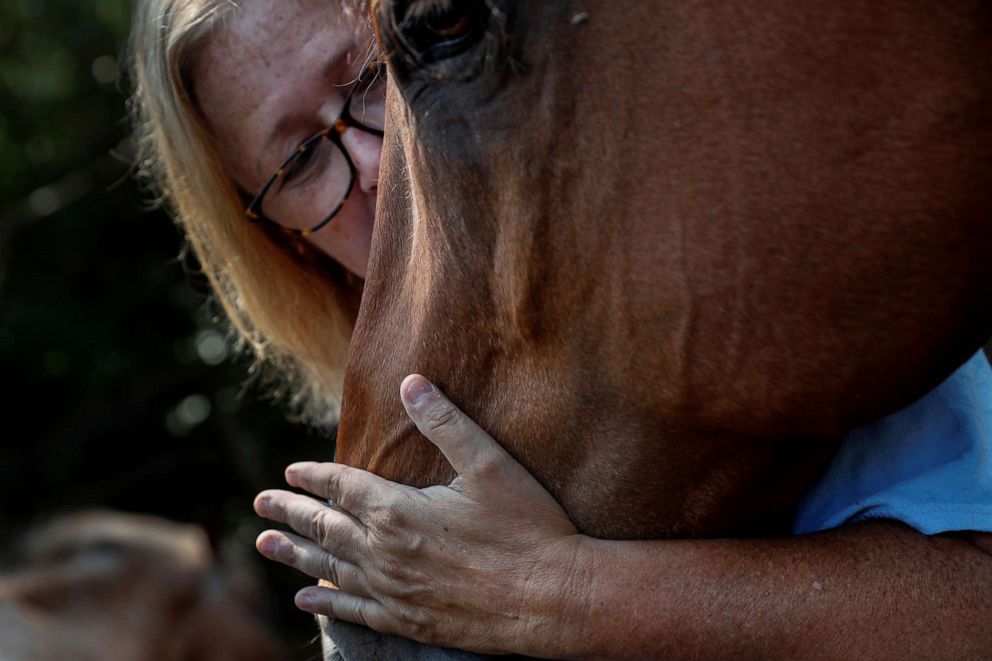PHOTO: Kayla Bergeron pets an equine therapy horse at Special Equestrians of Georgia in Milton, Ga., July 3, 2021. 