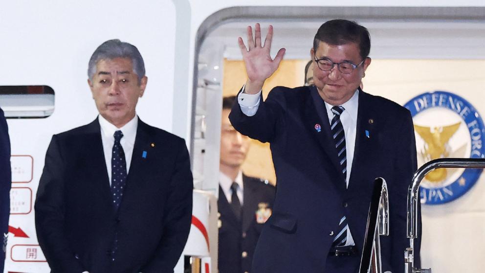 PHOTO: Japan's Prime Minister Shigeru Ishiba waves as he departs for a visit to the United States as Japan's Foreign Minister Takeshi Iwaya (L) looks on, at Tokyo International Airport at Haneda, Feb. 6, 2025.