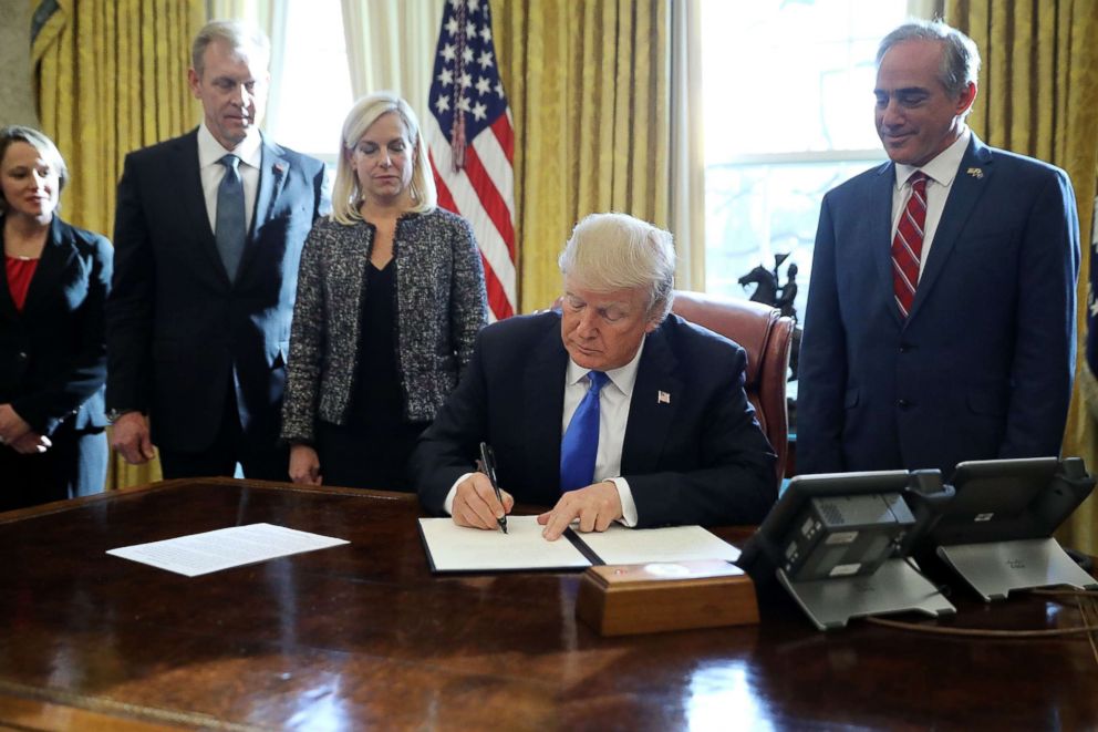 PHOTO: President Donald Trump signs an executive order supporting veterans as they transition from military to civilian life with Veterans Affairs Secretary David Shulkin, right, in the Oval Office, Jan. 9, 2018 in Washington.