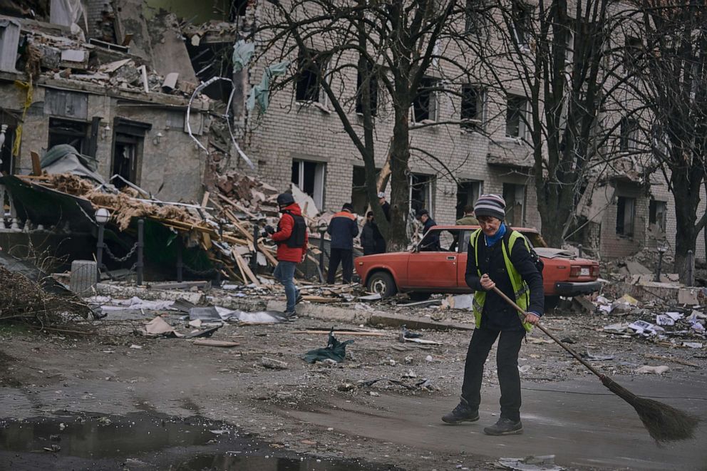 PHOTO: Communal workers clean the debris from the street in front of a heavily damaged building after a Russian attack in Sloviansk, Donetsk region, Ukraine, March 27, 2023.