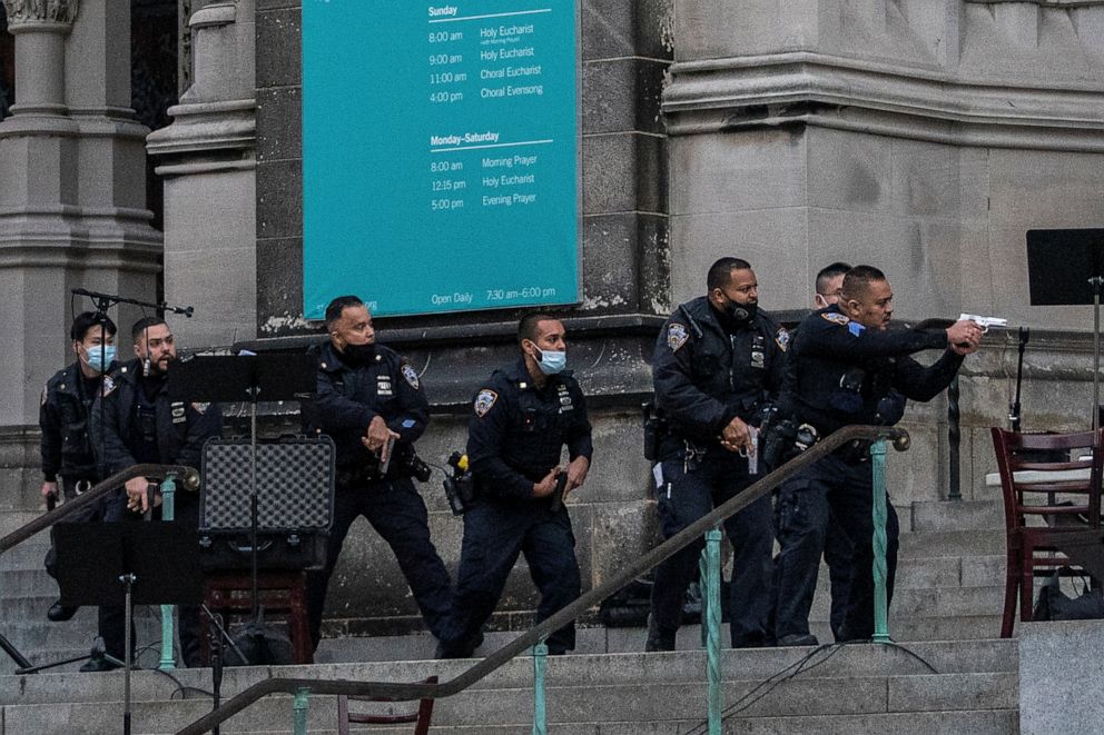 PHOTO: Police officers move towards a man who opened fire outside the Cathedral Church of St. John the Divine in the Manhattan borough of New York City, New York, U.S., December 13, 2020.
