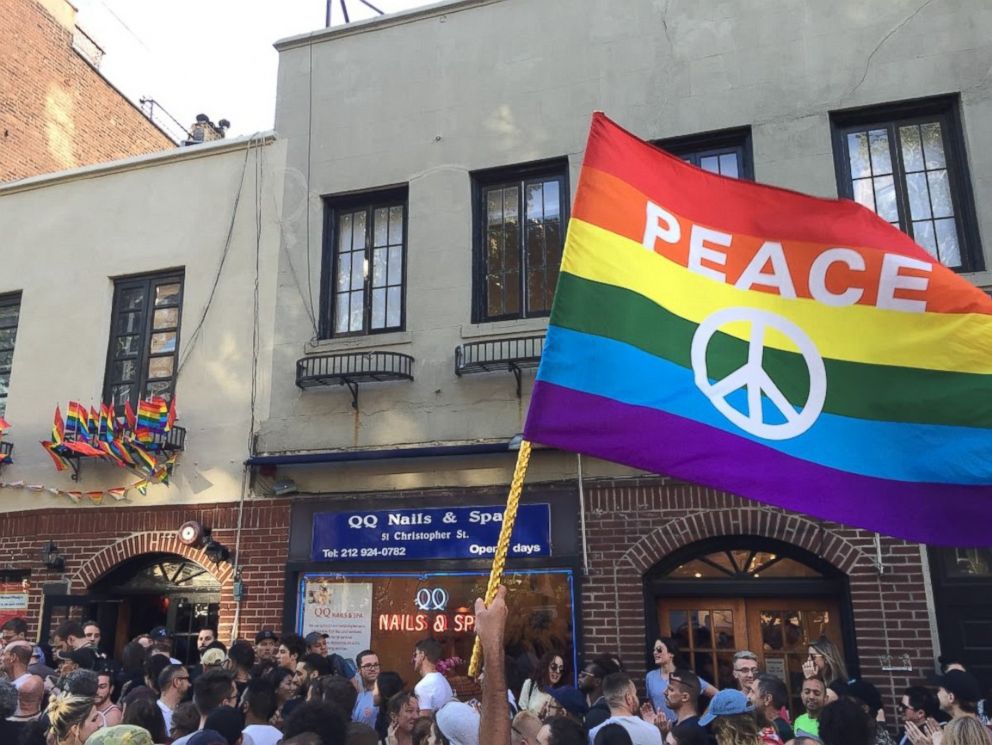 PHOTO: People gather outside the Stonewall Inn in New York City to pay tribute to the victims of a mass shooting at a gay club in Orlando, June 12, 2016.