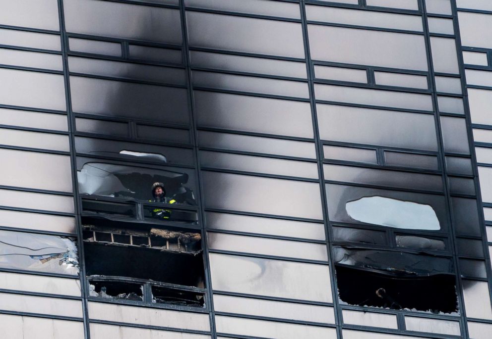 PHOTO: A firefighter looks out from the window of a damaged apartment in Trump Tower in New York on April 7, 2018. 