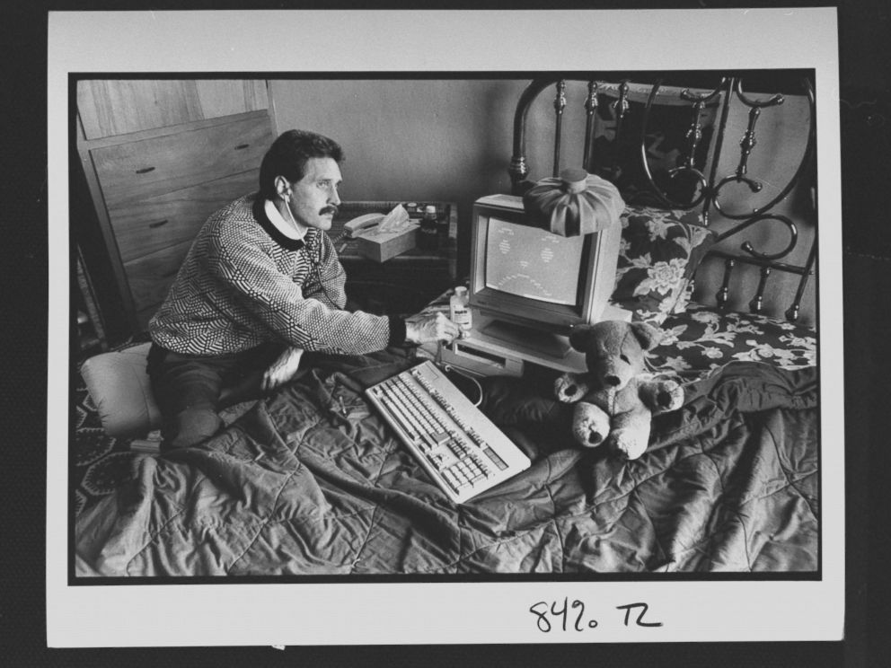 PHOTO: Computer analyst John McAfee holding stethoscope to IBM type computer sitting on bed w. ice bag on top, illustrating computer virus which McAfee is able to eradicate; at home.