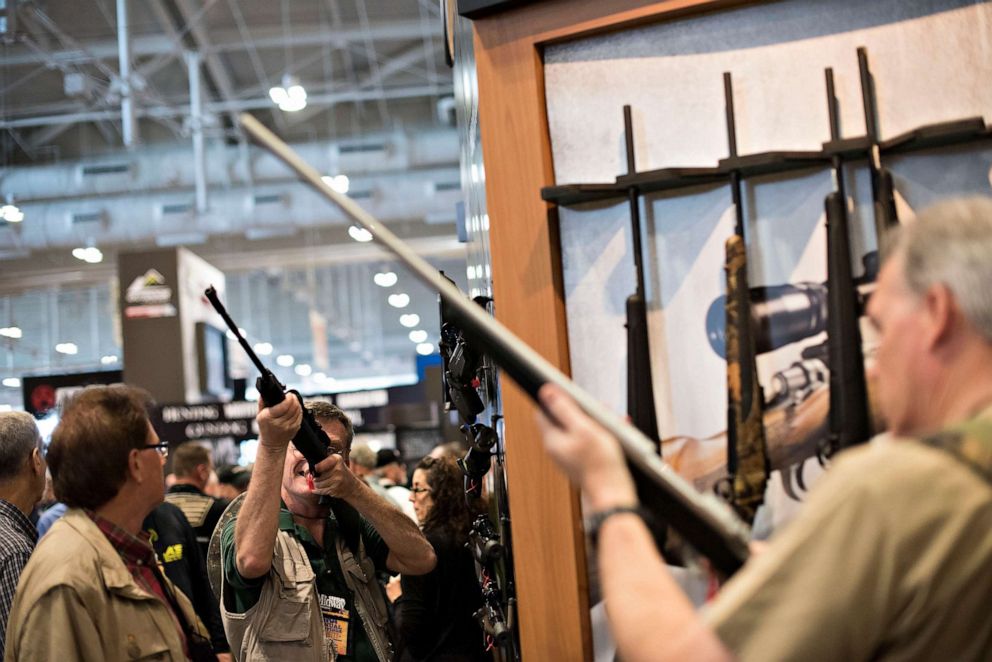 PHOTO: Attendees look over items in the Remington Arms Co. LLC booth on the exhibition floor of the 144th National Rifle Association (NRA) Annual Meetings and Exhibits at the Music City Center in Nashville, Tenn., April 11, 2015.
