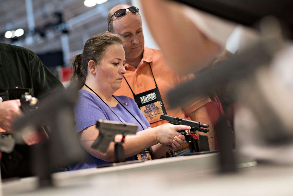 PHOTO: Atendees look over Glock, Inc. pistols on the exhibition floor of the 144th National Rifle Association (NRA) Annual Meetings and Exhibits at the Music City Center in Nashville, Tenn., April 11, 2015.