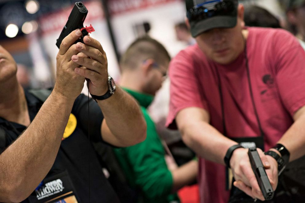 PHOTO: Attendees look over Glock, Inc. pistols on the exhibition floor of the 144th National Rifle Association (NRA) Annual Meetings and Exhibits at the Music City Center in Nashville, Tenn., April 11, 2015.
