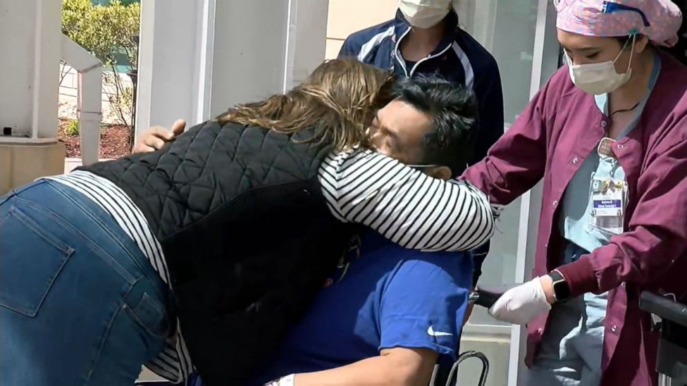 PHOTO: Amanda Phommachanh embraces her husband, Titou Phommachanh, after he was released from a three-week hospital stay due to the novel coronavirus. 