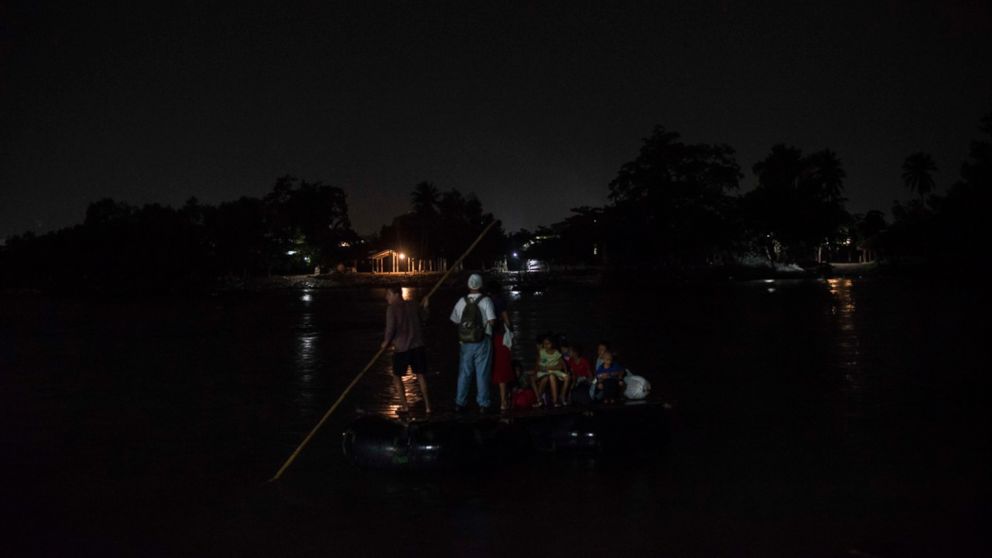 A Honduran couple crosses Suchiate river with them three children in the middle of the night. 