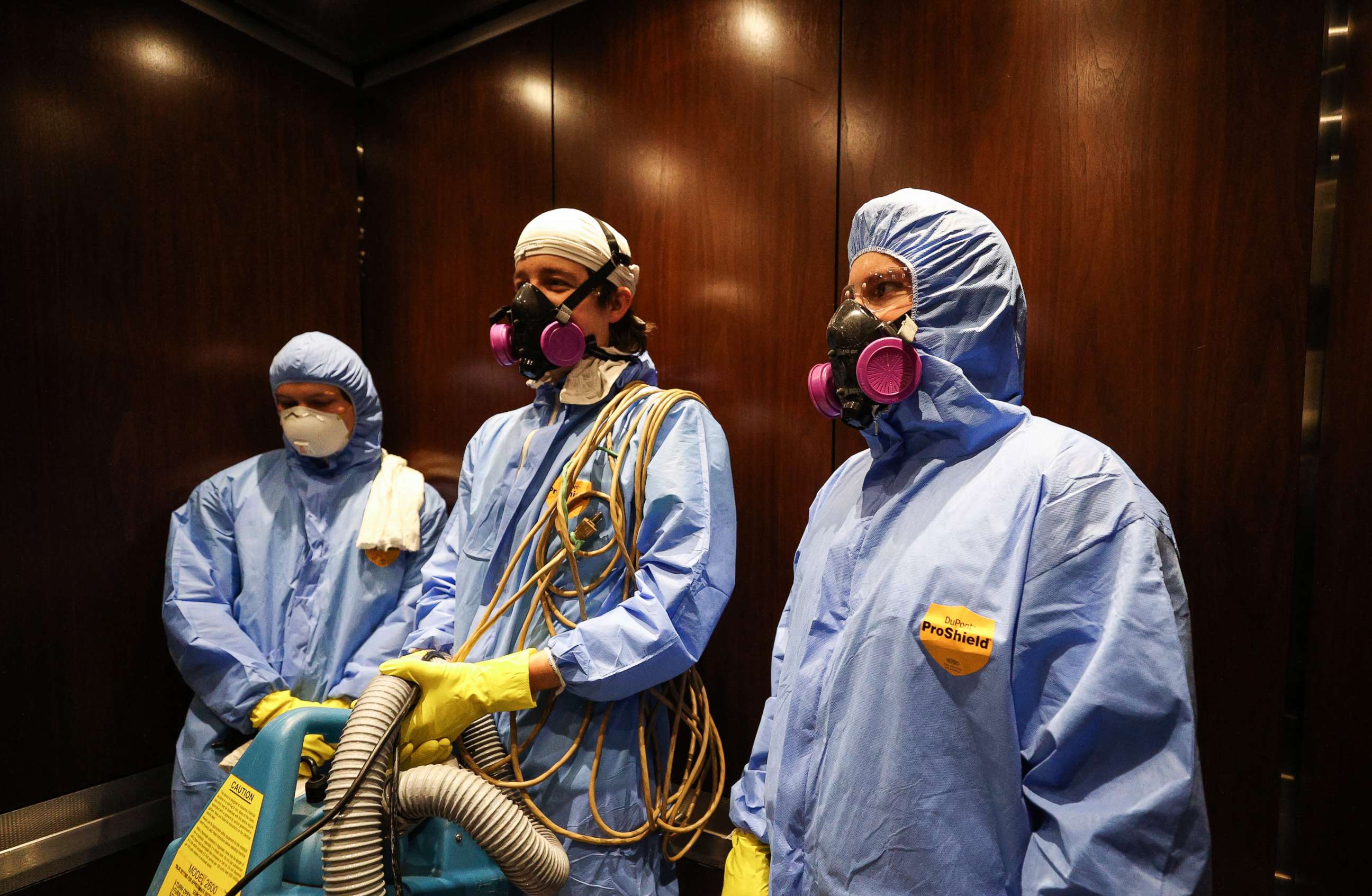PHOTO: Maryland Cleaning and Abatement Services employees Graham Sevy (L), Bob Wiglesworth, (C) and Alec Pine (R) ride in an elevator before preforming a preventative fogging and damp wipe treatment on March 21, 2020 in Hunt Valley, Maryland. 