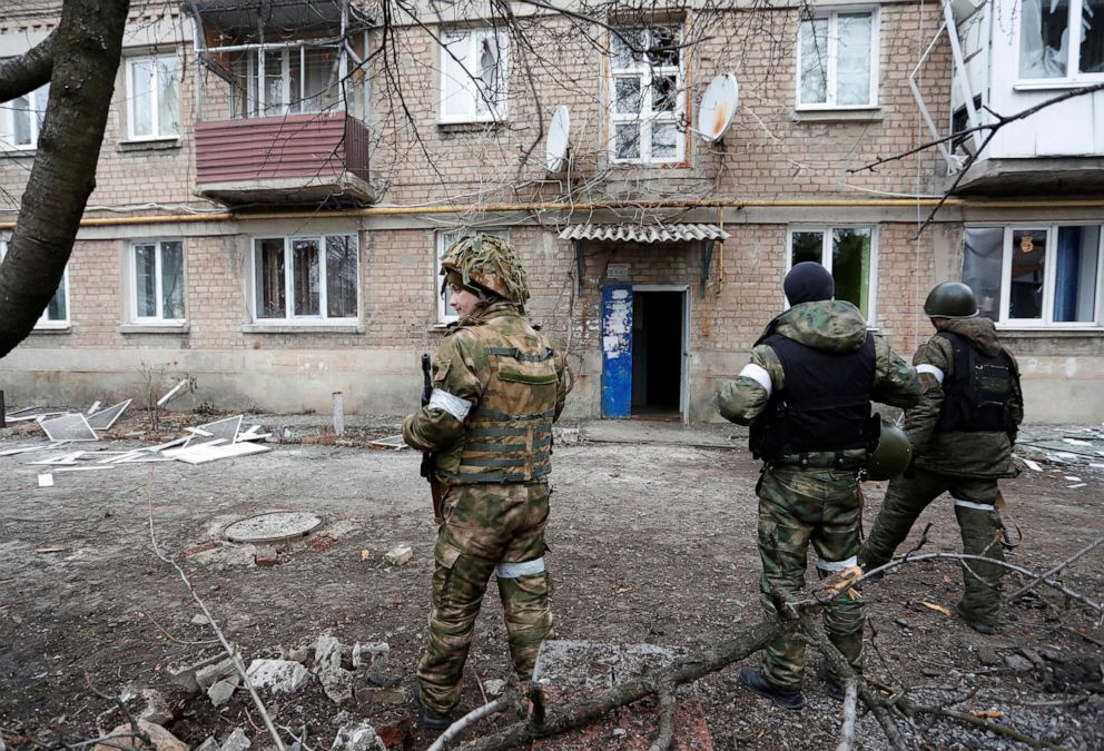 PHOTO: Militants of the self-proclaimed Donetsk People's Republic stand in front of an apartment building in the Donetsk region, Ukraine, Feb. 24, 2022.