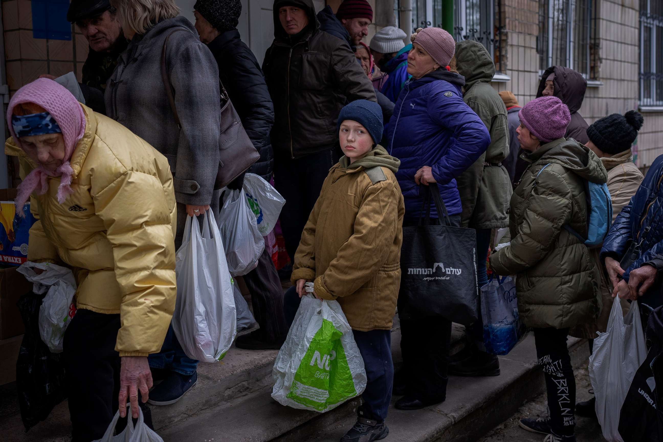 PHOTO: Sergei, 11, waits his turn to receive donated food during an aid humanitarian distribution in Bucha, in the outskirts of Kyiv, Ukraine, April 19, 2022. 