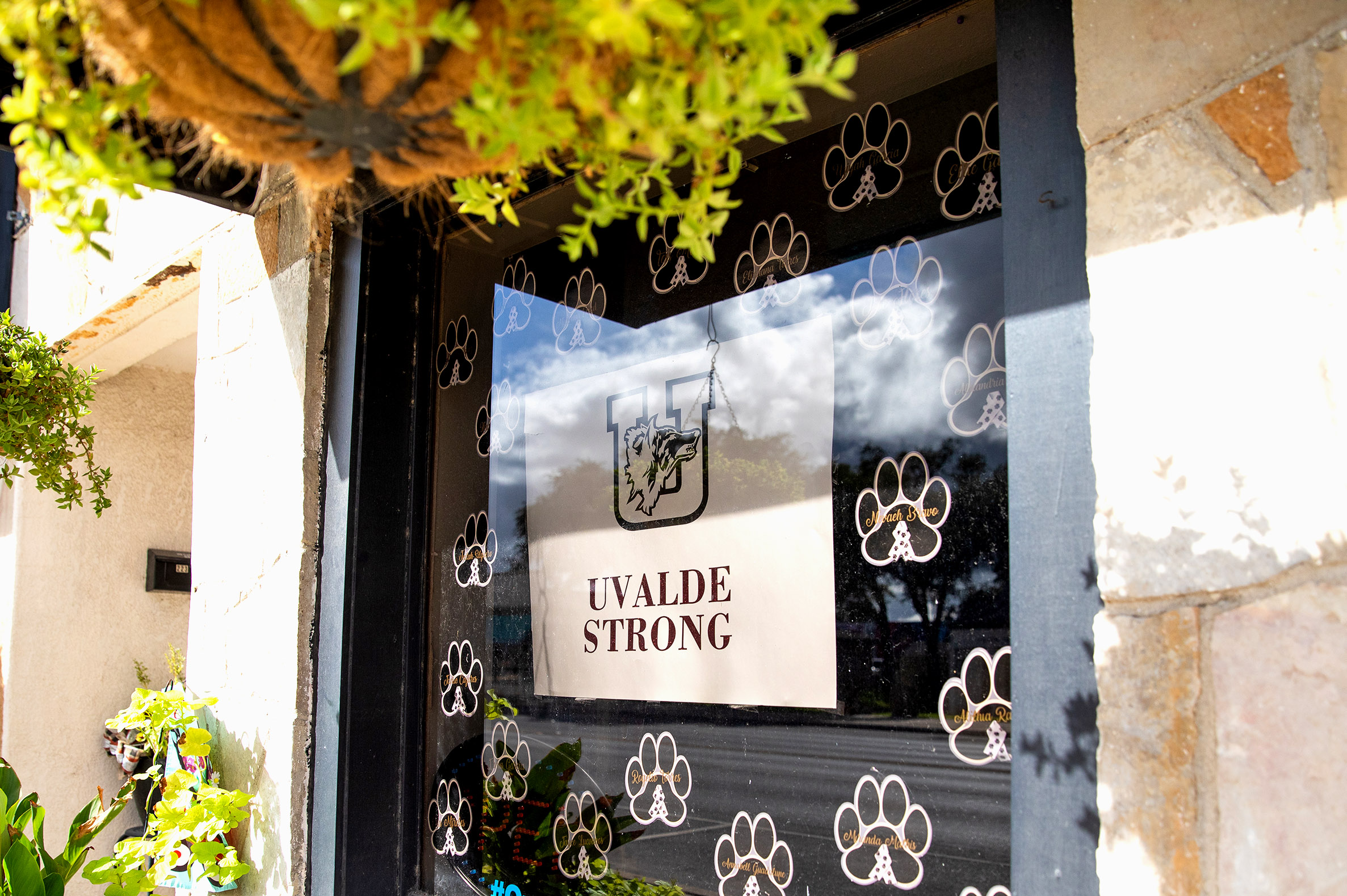 PHOTO: A sign with the "Uvalde Strong" message and a Uvalde High School Coyote logo is displayed on the window of a building in downtown Uvalde, Texas, on Aug. 21, 2022