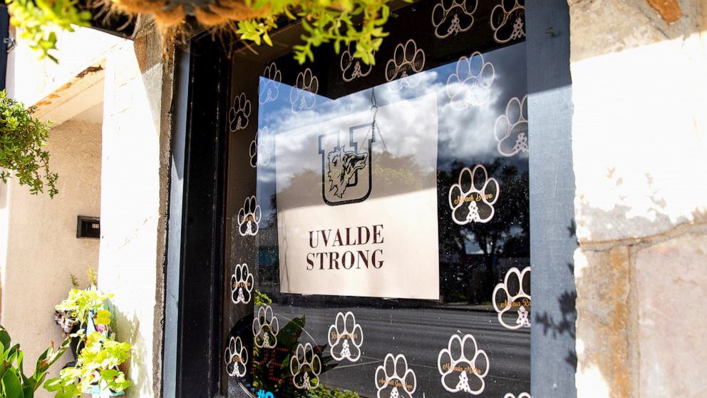 PHOTO: A sign with the "Uvalde Strong" message and a Uvalde High School Coyote logo is displayed on the window of a building in downtown Uvalde, Texas, on Aug. 21, 2022