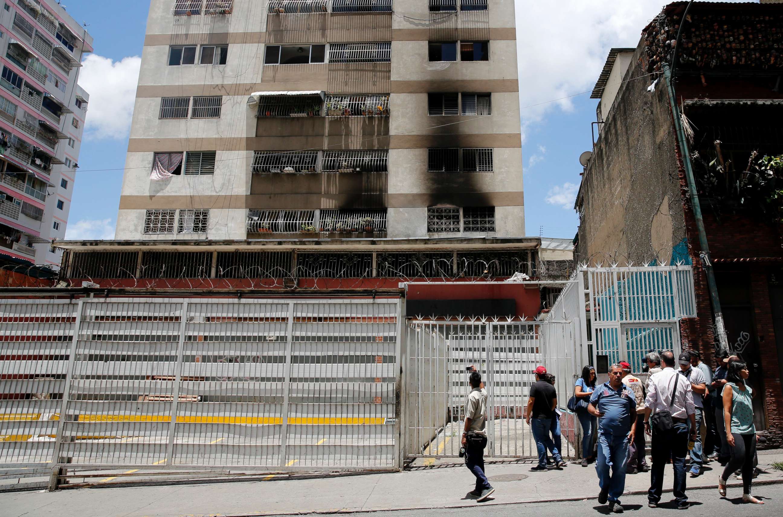 PHOTO: Press members wait as they try to get access to an apartment complex where an allegedly armed drone crashed, causing a fire, in Caracas, Venezuela, Aug. 5, 2018.