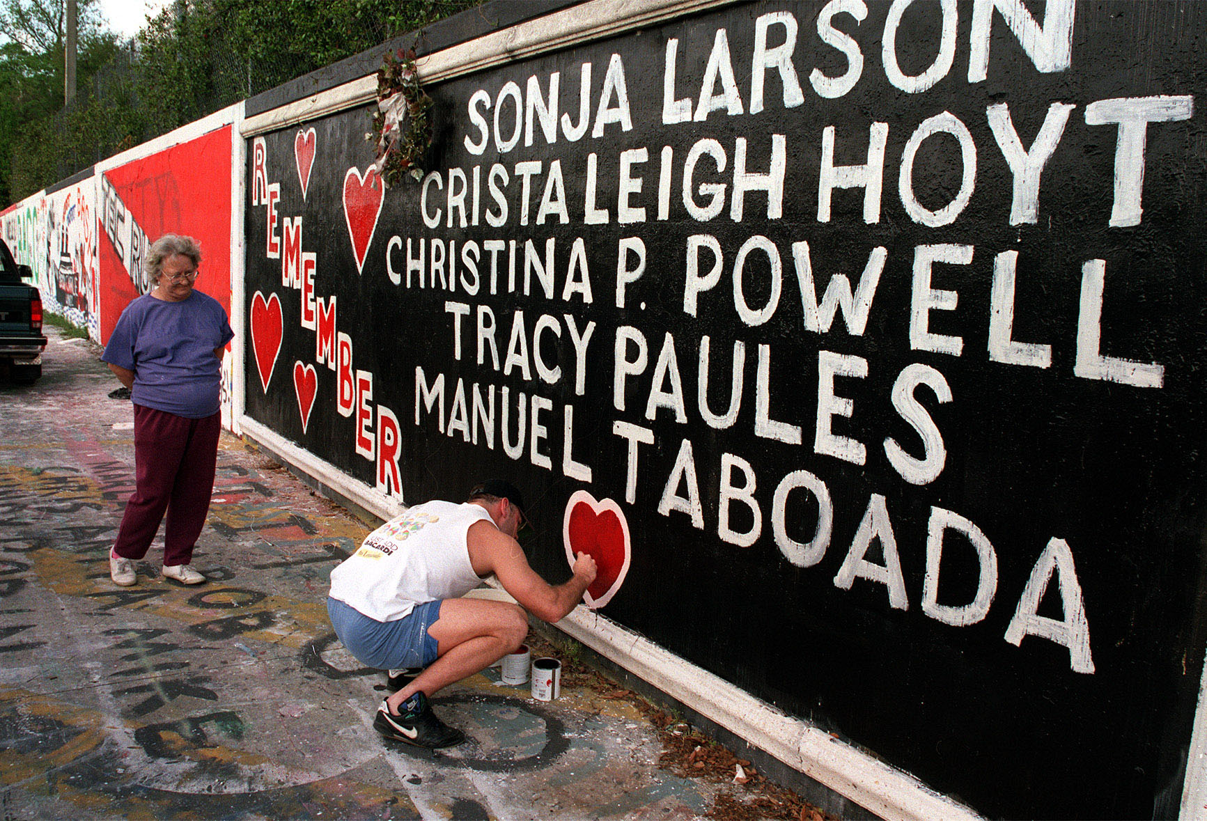 PHOTO: Tony Mekeel repaints one of the hearts on the 34th Street Wall memorial as Ann Garren, the mother of slain student Christa Hoyt, watches. Mekeel was a neighbor of one of the slain students, Manuel Taboada, during the ordeal in 1990.