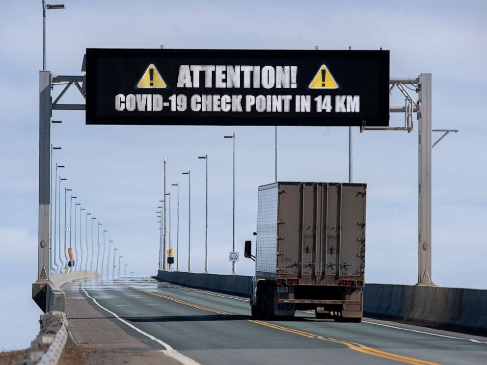 PHOTO: A sign indicates that provincial health department workers will stop traffic that has crossed the Confederation Bridge in Cape Jourimain, New Brunswick. on Sunday, March 22, 2020. 
