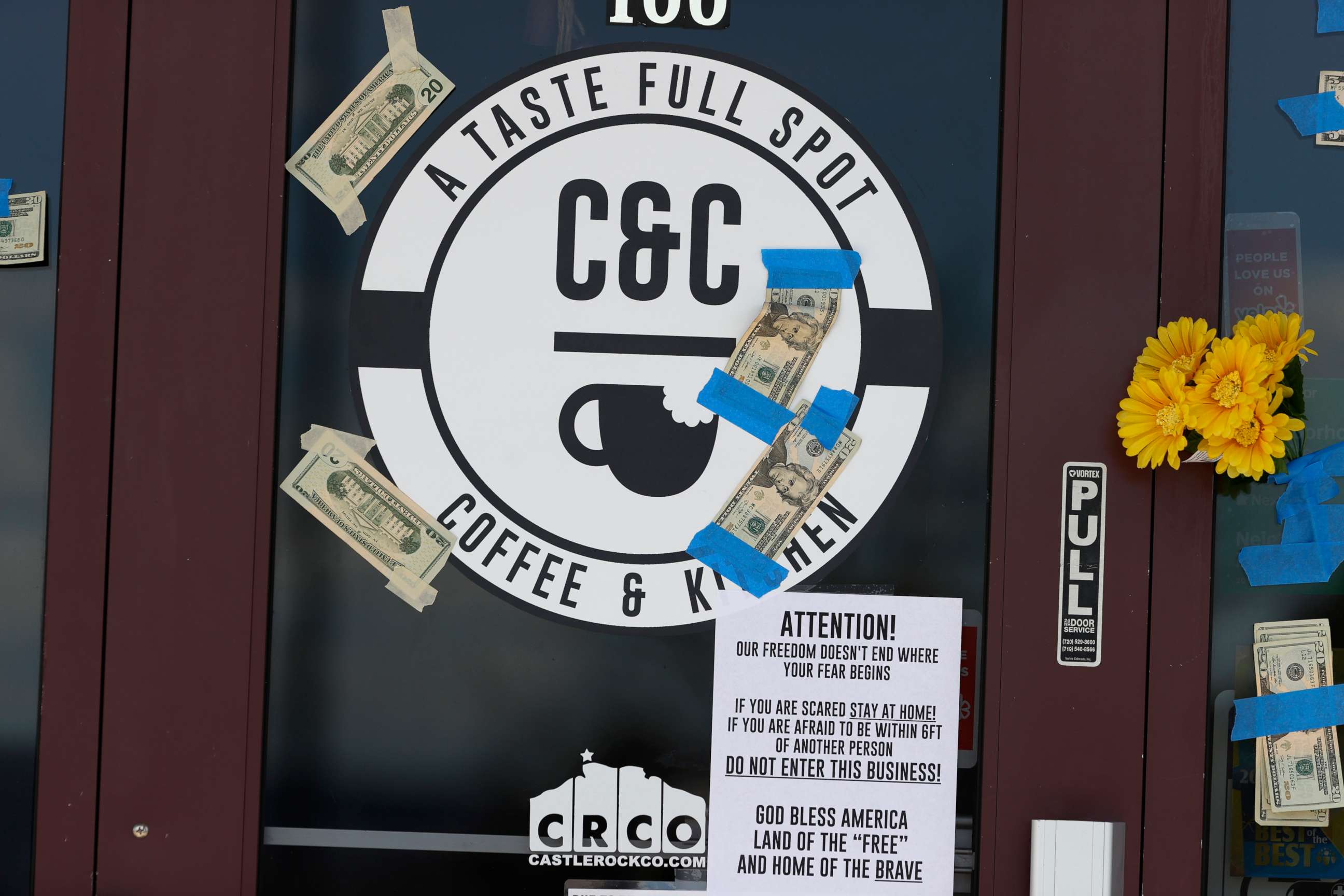 PHOTO: Paper bills from supporters are taped to the windows on the front of C&C Coffee and Kitchen Tuesday, May 12, 2020, in Castle Rock, Colo. 
