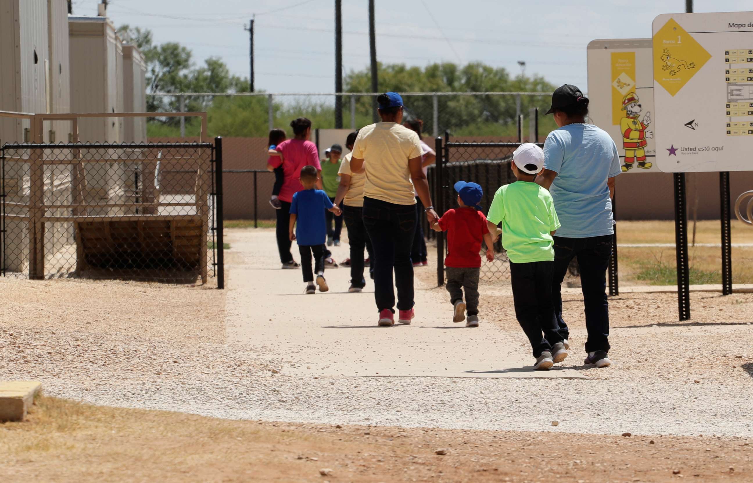 PHOTO: FILE - In this Aug. 23, 2019 file photo, immigrants seeking asylum hold hands as they leave a cafeteria at the ICE South Texas Family Residential Center in Dilley, Texas. 