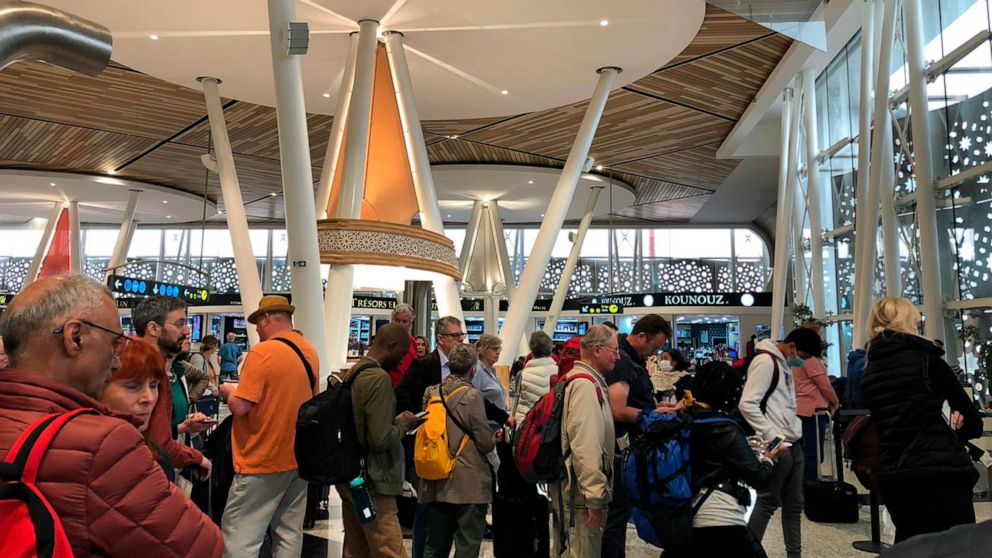 PHOTO: Passengers line up to board one of the few flights out of Morocco in Marrakech, Thursday, March 19, 2020. Morocco suspended all international passenger flights and passengers ships to and from its territory on Sunday.