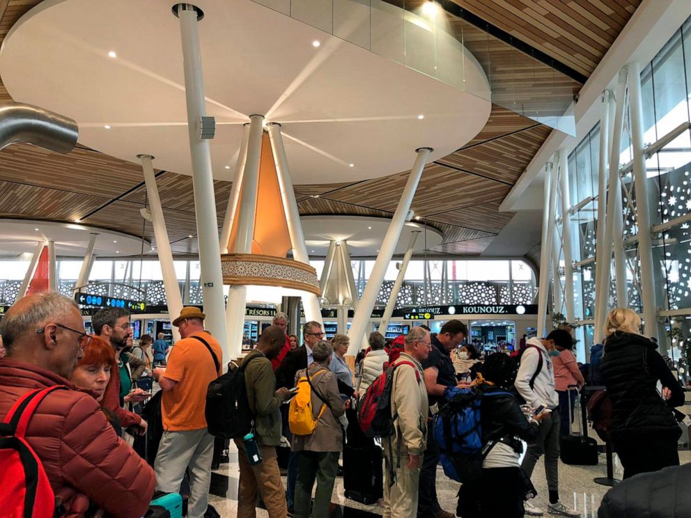 PHOTO: Passengers line up to board one of the few flights out of Morocco in Marrakech, Thursday, March 19, 2020. Morocco suspended all international passenger flights and passengers ships to and from its territory on Sunday.