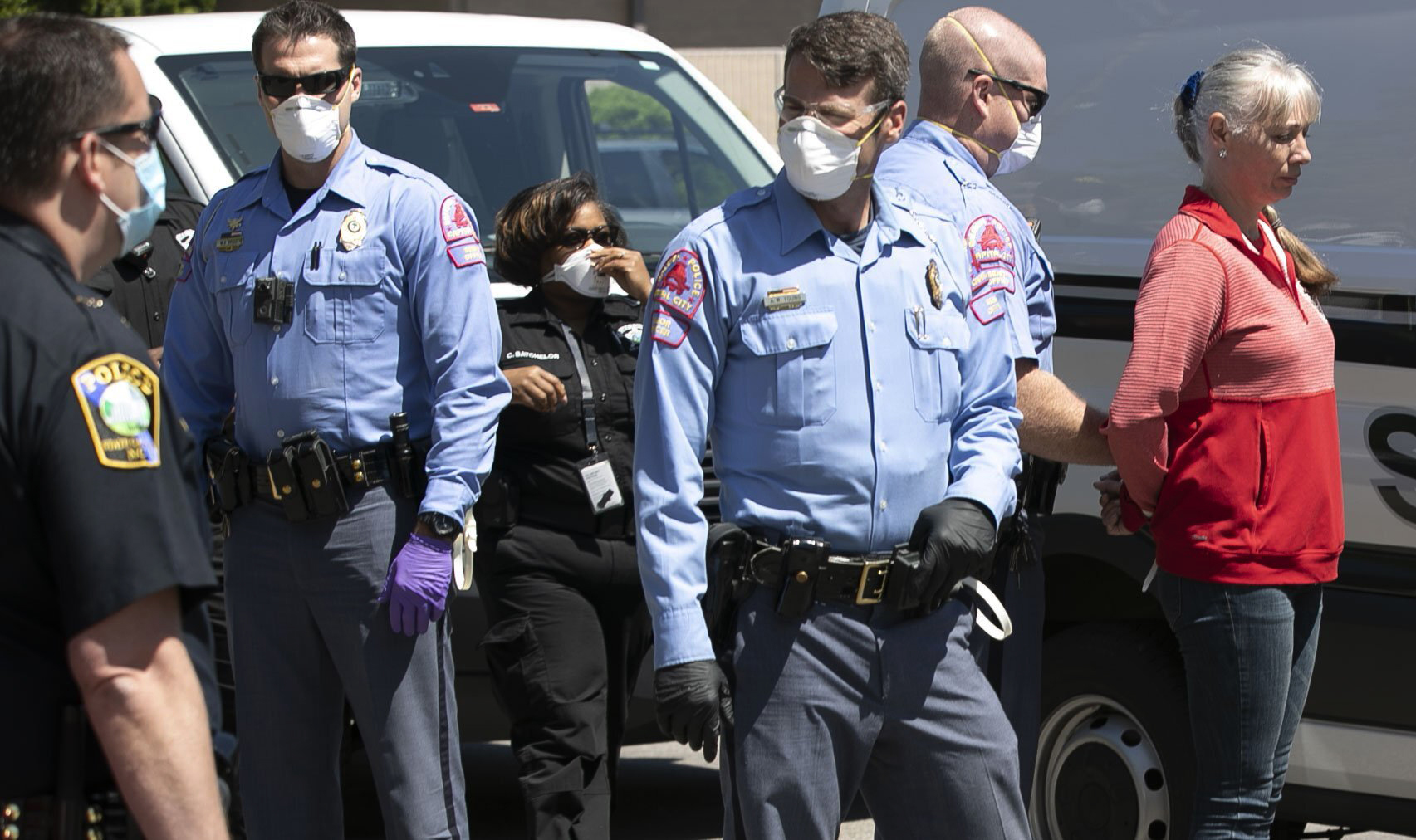 PHOTO: Police arrest a woman after she was told several times to disperse from a gathering of protestors calling on Governor Roy Cooper to re-open North Carolina on Tuesday, April 14, 2020, in Raleigh, N.C. 