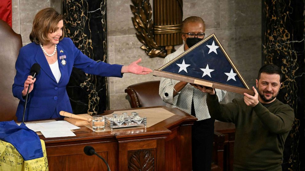 PHOTO: Ukraine's President Volodymyr Zelensky hoists a US national flag he received from House Speaker Nancy Pelosi following his address to the US Congress in Washington, Dec. 21, 2022.
