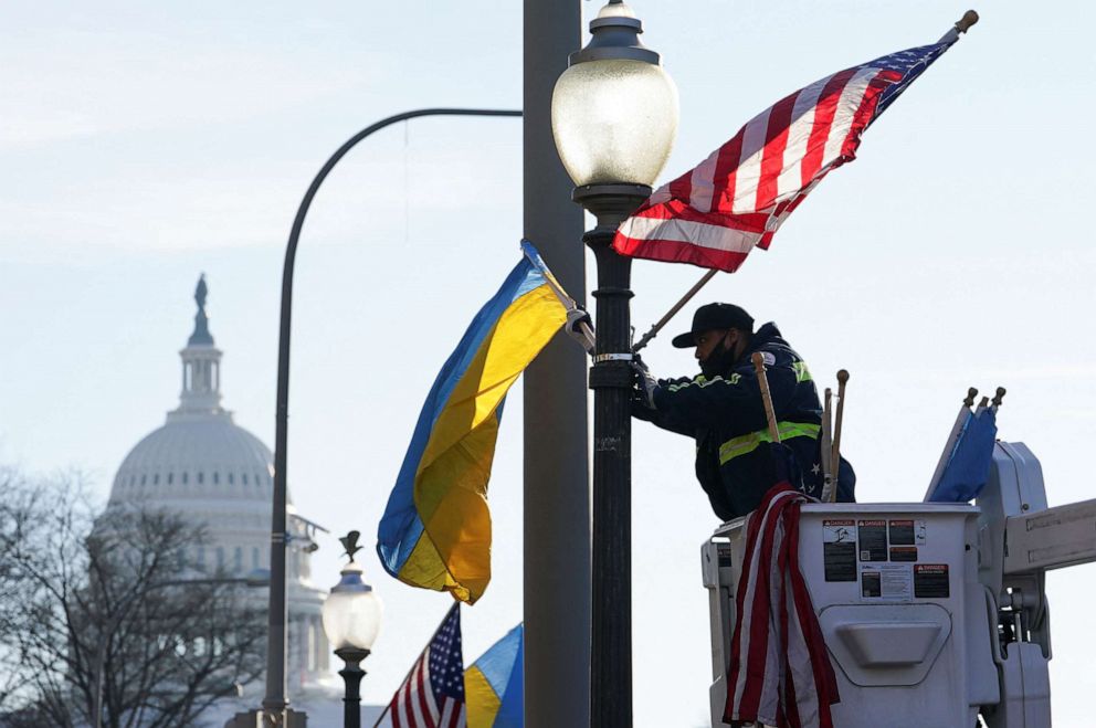PHOTO: A worker installs Ukrainian and U.S. flags near the U.S. Capitol ahead of a visit by Ukraine's President Volodymyr Zelenskyy for talks with President Joe Biden and an address to a joint meeting of Congress, Dec. 21, 2022, in Washington.