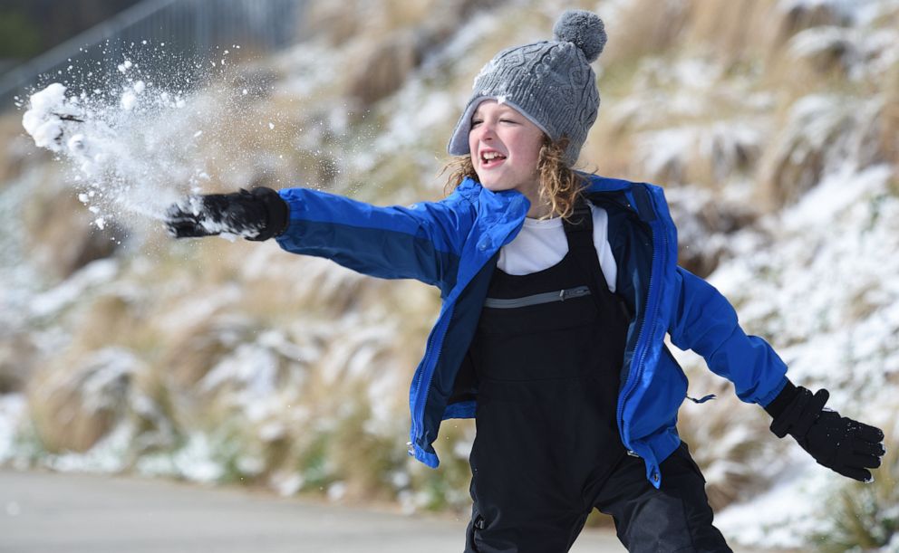 PHOTO: Ian Mattson, 9, throws a snowball at his sister Elise, 5, as they play in Renaissance Park, March 12, 2022, In Chattanooga, Tenn.