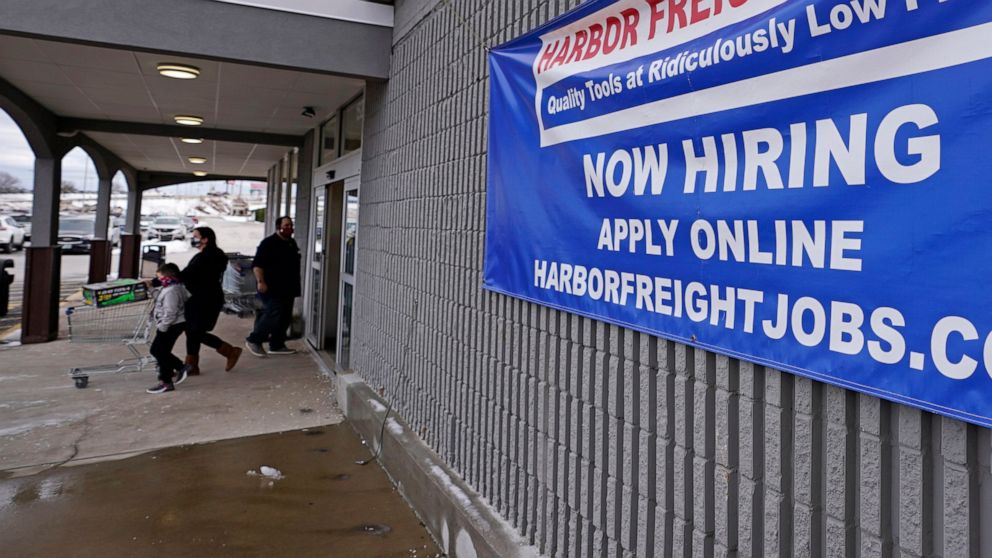 FILE - In this Dec. 10, 2020, file photo, a "Now Hiring" sign hangs on the front wall of a Harbor Freight Tools store in Manchester, N.H. When the U.S. government issues the September jobs report on Friday, Oct. 8, 2021, the spotlight will fall not o